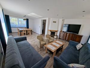 a living room with couches and a tv and a table at Agroturystyka Julinka in Olszyny
