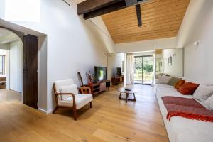 a living room with a white couch and a tv at Villa des Résiniers, proche plage & forêt, wifi in Moliets-et-Maa