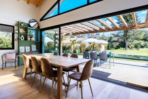 a dining room with a wooden table and chairs at Villa des Résiniers, proche plage & forêt, wifi in Moliets-et-Maa