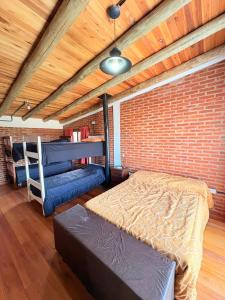 a bedroom with two beds and a brick wall at Casa Parque Rio Uruguay in Concordia