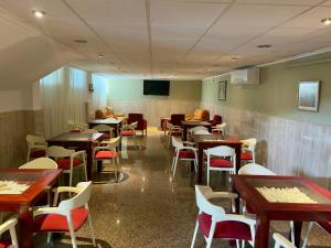 a dining room with tables and chairs and a tv at Hotel Villa Naranjos in Jávea