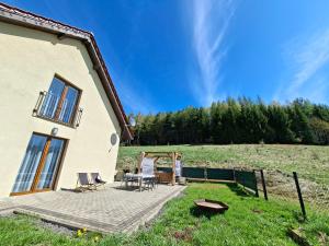 a patio of a house with a table and chairs at Agroturystyka Julinka in Olszyny