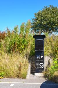 a black trash can sitting on the side of a road at Seeperle Meerleben in Carolinensiel