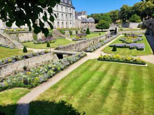 a garden in front of a building with flowers at L'Échappée en Sandales in La Gacilly