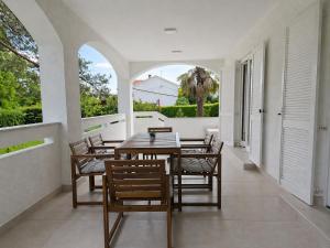 a dining room with a table and chairs on a balcony at Apartman Filip in Risika