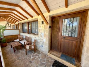 a porch with a wooden door and a table and chairs at Eleon apartments in Kalamata