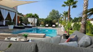 a swimming pool with couches and a swimming pool at logement ensoleillé in Cardet
