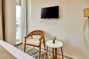 a room with a chair and a tv on a wall at Palmeras Pyramids Hotel in Cairo