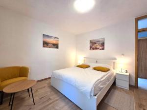 a bedroom with a white bed and a chair at Apartman Filip in Risika