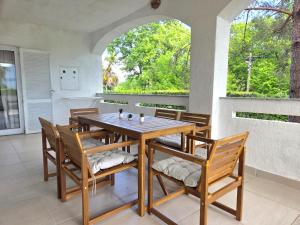a dining room with a wooden table and chairs at Apartman Filip in Risika