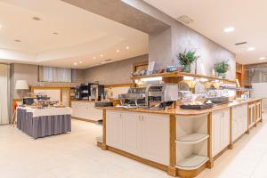 a large kitchen with a counter with dishes on it at Hotel Master in Brescia