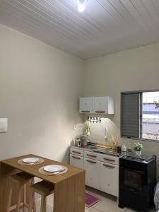 a kitchen with a table and a counter top at Aconchego da Si AP in Nova Mutum +6 photos