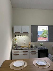 a kitchen with a table with two plates on it at Aconchego da Si AP in Nova Mutum
