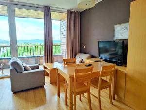 a living room with a dining table and a television at Villa Mari I in Maribor