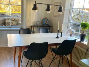 a dining room table with four chairs and a candle at Charmig lägenhet nära Smögenbryggan in Smögen +7 photos