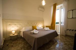 a bedroom with a bed with two towels on it at BIANCA ROOMS in Noto