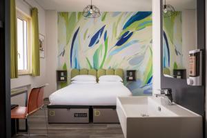 a bedroom with a bed and a sink and a painting at The RomeHello in Rome +146 photos
