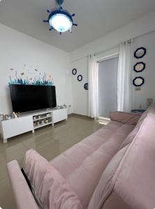 a living room with a couch and a flat screen tv at A pasos de la playa y el centro de Bayahibe in Bayahibe
