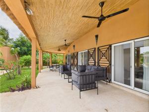 a patio with black chairs and a ceiling fan at Villa Épuré Tribale in Darou Rhamane