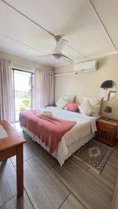 a bedroom with a large bed and a window at Yolonwabo Bed & Beakfast in East London