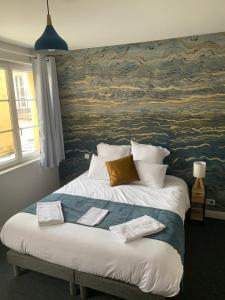 a bedroom with a large bed with a painting on the wall at Résidence Saint Pôl in Nogent-le-Rotrou