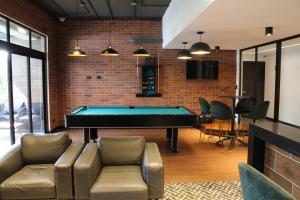 a living room with a pool table and a brick wall at EON One Bedroom Apartment 1305 in Estación Pamplona