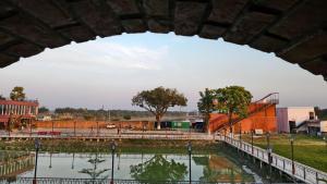 a bridge over a body of water with a train at MAHFIL-e-MOTIJHEEL, MOTIJHEEL PARK AND RESORT in Lālbāgh