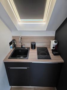 a kitchen with a sink and a counter top at Studio détente, sdb privative, billard, air soccer, clim in Verviers