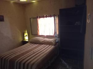 a small bedroom with a bed and a window at El PRADO in Alta Gracia +4 photos