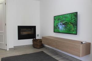a living room with a flat screen tv on a wall at Recanto da Malhadoira in Currais