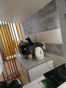 a small kitchen with a table with a microwave and acomputer at Le lys in Saintes +5 photos