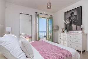 a bedroom with a bed with a dresser and a window at Villa Athena in Agios Nikolaos