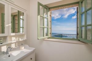 a bathroom with a window with a view of the ocean at Villa Athena in Agios Nikolaos