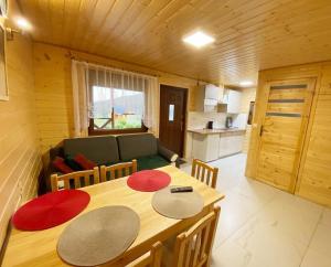 a wooden room with a table and a couch at Bieszczadzkie domki z widokiem 793-903-243 in Bukowiec