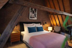 a bedroom with a large bed with blue pillows at Koffie&kussens in Middelburg