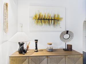 a living room with a table with a lamp and a painting at Villa Épuré Tribale in Darou Rhamane