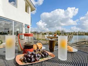 a table with a plate of food and drinks at Squirrels Leap Lake Views with Spa Access, Lower Mill Estate in Somerford Keynes