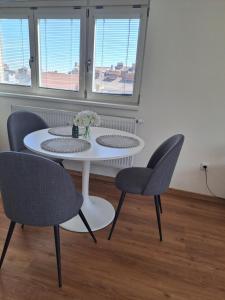 a white table and chairs in a room with windows at Apartman MWM Brno 2 in Brno +7 photos