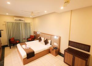 a hotel room with a bed and a table and chairs at Nexstay Hotel Calicut Gate in Kozhikode