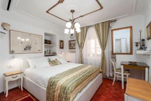 a bedroom with a large white bed and a desk at Mia Casa Dubrovnik in Dubrovnik