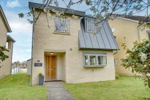 a brick house with a brown door and windows at Squirrels Leap Lake Views with Spa Access, Lower Mill Estate in Somerford Keynes
