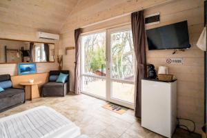 a living room with a large window and a tv at Къщички Синьо лято, Черноморец - Варна - Blue Summer Houses Varna in Varna City