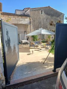 a patio with a table and an umbrella at Le lys in Saintes