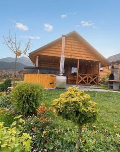 a large wooden house with bushes in front of it at Bieszczadzkie domki z widokiem 793-903-243 in Bukowiec