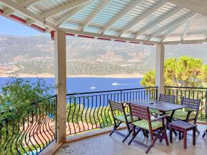 a table and chairs on a balcony with a view of the water at Villa Noa Amazing Sea view in Kaş