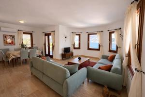 a living room with two couches and a dining room at Villa Noa Amazing Sea view in Kaş