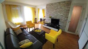 貝爾格勒的住宿－貝爾維爾雙生公寓，客厅配有真皮沙发和黄色椅子