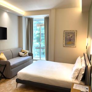 a hotel room with a bed and a couch at Giardini Rooms in Cremona