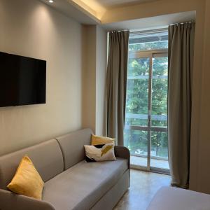 a living room with a couch and a large window at Giardini Rooms in Cremona +38 photos