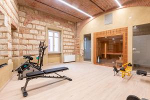 a gym with a brick wall and two exercise bikes at OLIVOLA APARTMENTS in Frassinello